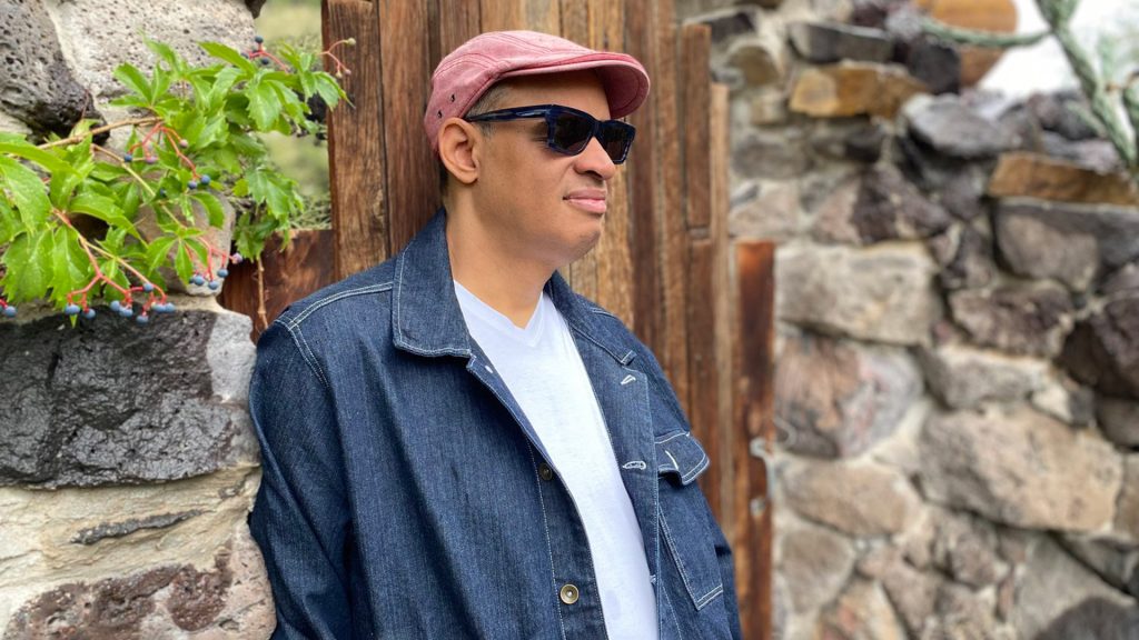 man leaning against stone wall