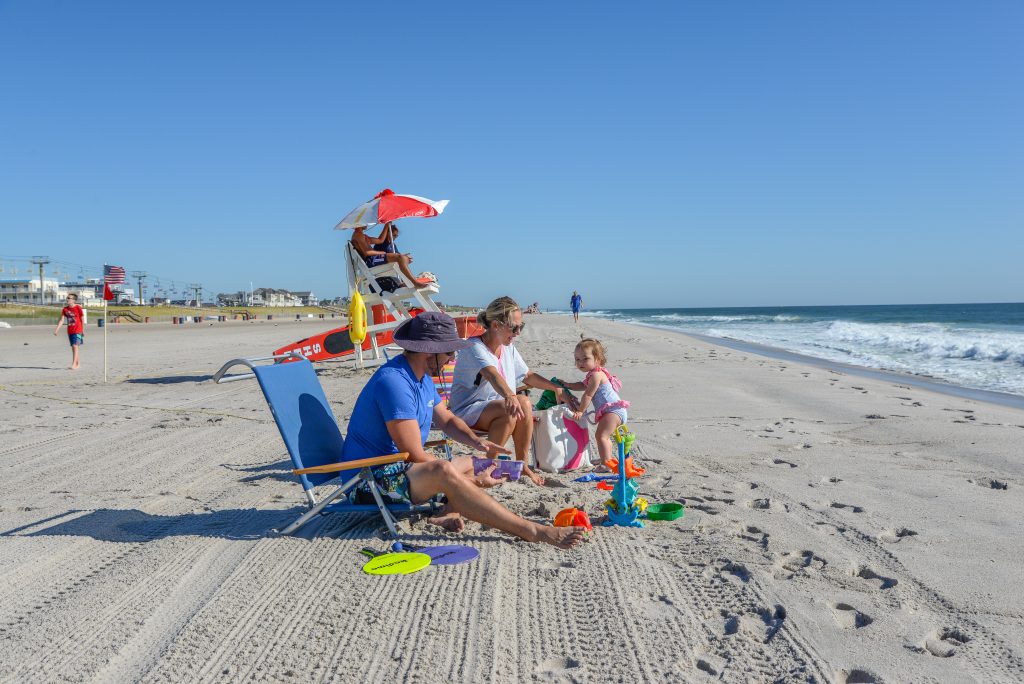 Family on beach in front of lifeguard stand