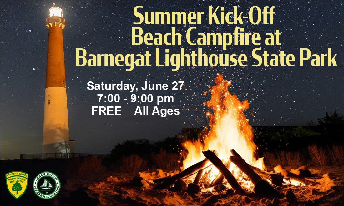 bonfire on beach in front of lighthouse