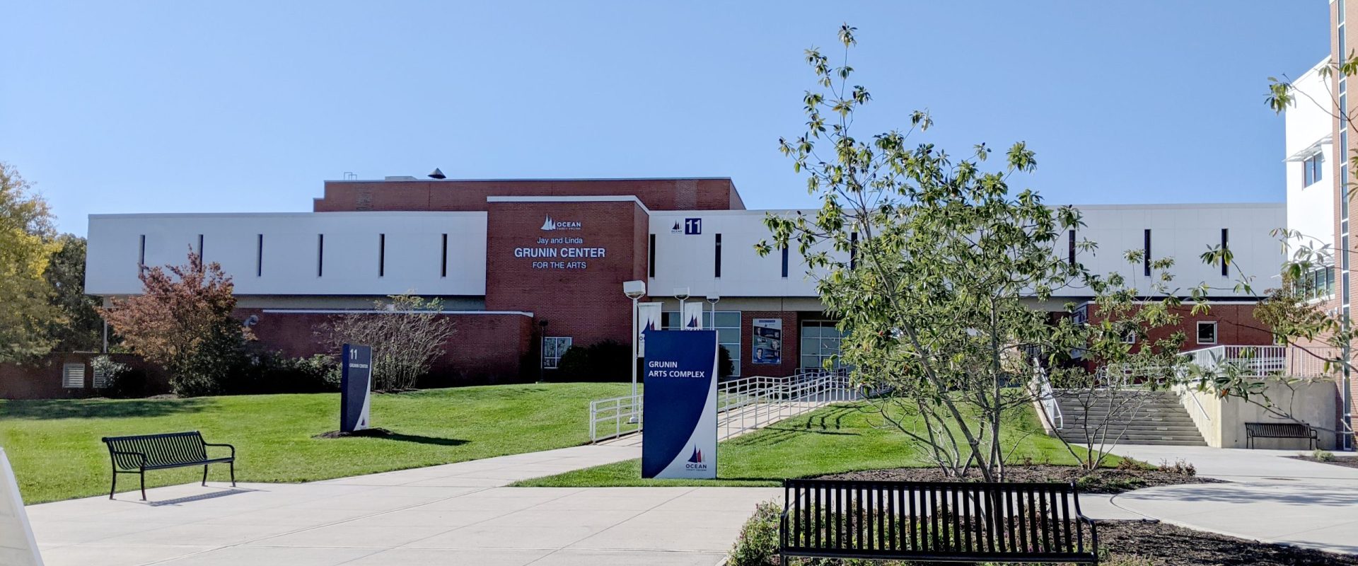 picture of a building with a bench and trees in front of it