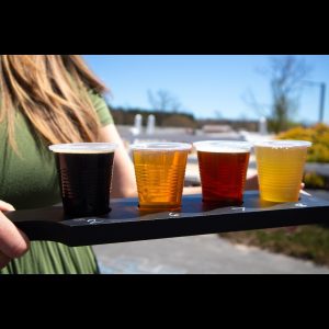 woman holding flight of beer