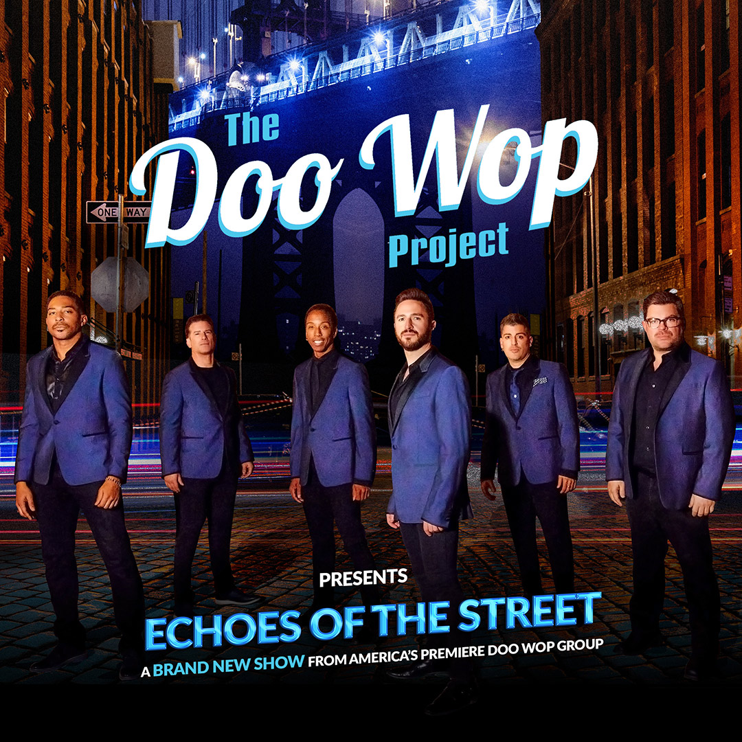 six people wearing blue suit jackets standing together to pose for a picture with a city as the background