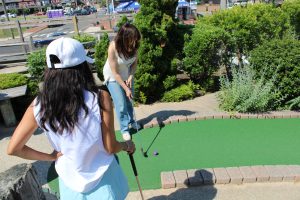 Two women playing miniature golf