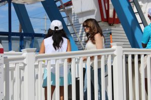 Two people talking by a ride in an amusement park