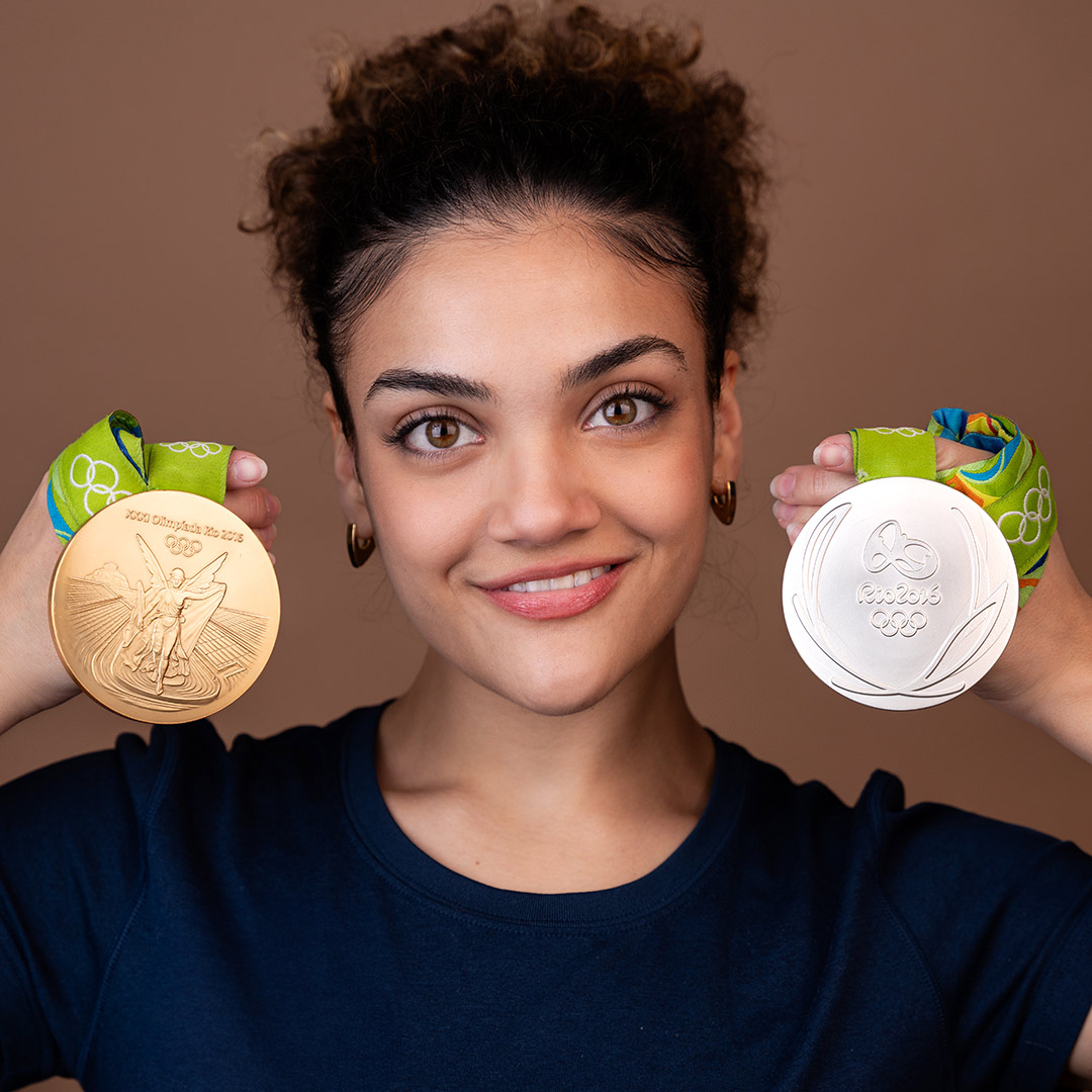 woman holding two medals