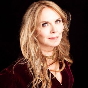 photo of a woman with blonde hair in a red velvet top 