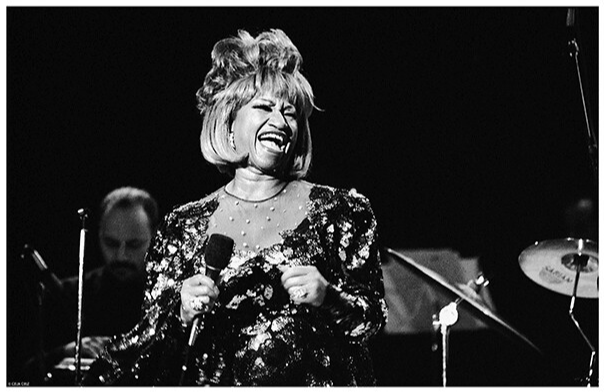 Celia Cruz holding a microphone on a stage