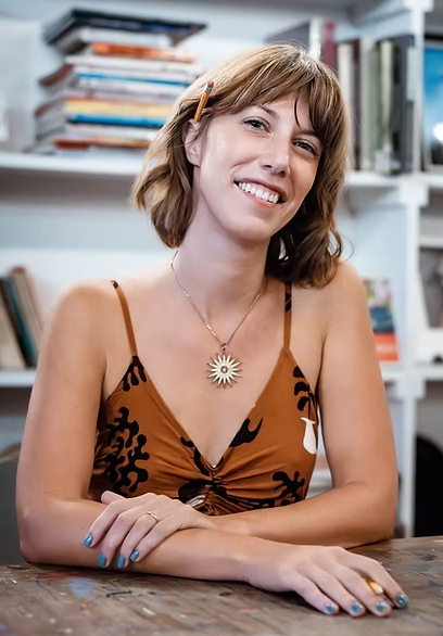 picture of a woman sitting down with her arms folded leaning on a table