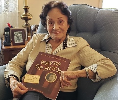 Photo of a woman holding a book sitting on a couch